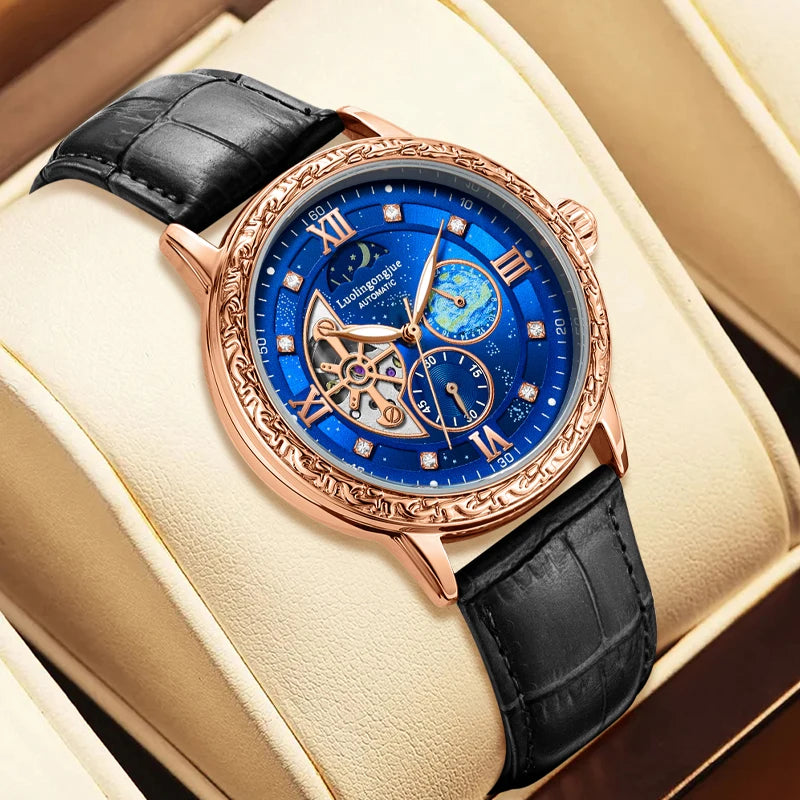 Luxury watch with blue face and black leather strap on beige cushion